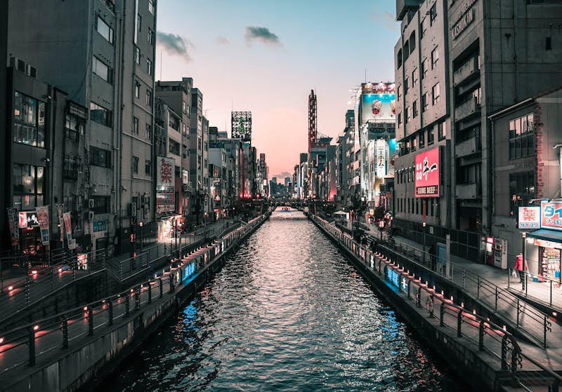 Dotonbori Canal in Osaka at twilight with vibrant lights reflecting on water