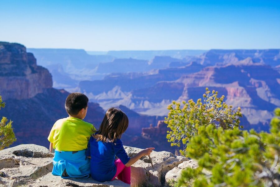 Two kids on a family trip, looking out over the water